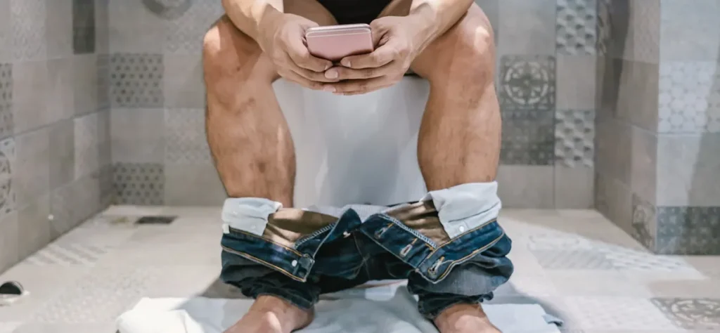 pessoa usando celular - banheiro